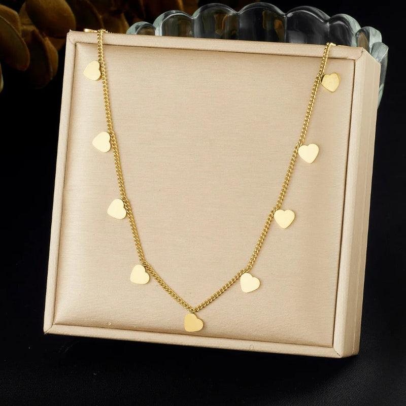 Gold necklace with heart pendants on a beige display box