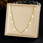 Gold necklace with heart pendants on a beige display box