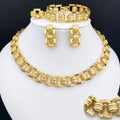 Gold jewelry set including necklace, earrings, and bracelet on a white stand.