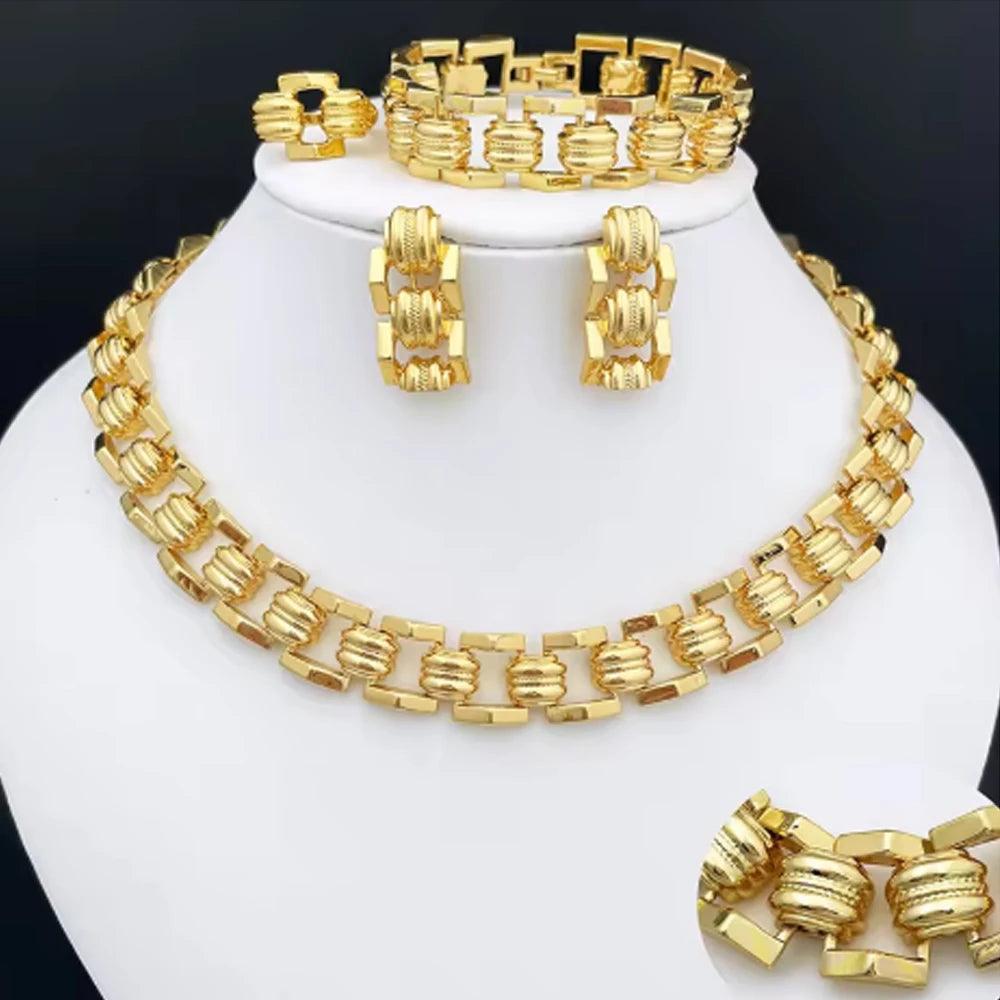 Gold jewelry set including necklace, earrings, and bracelet on a white stand.