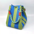 Green and blue striped bag with a colorful handle on a white background