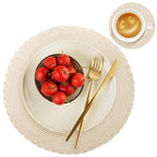 Dinner setting with a bowl of red apples, gold fork and knife, and a cup of coffee on a white background.