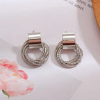 Silver circular earrings on a light background with floral elements