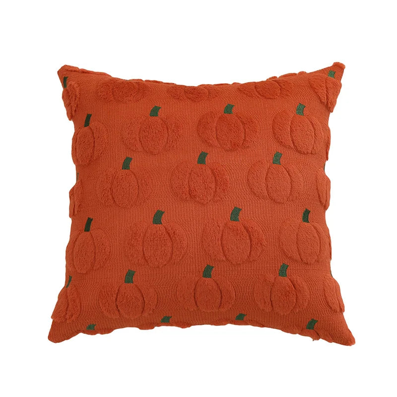 An orange textured throw pillow featuring a raised pumpkin pattern with small green stems, shown against a plain white background.