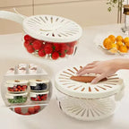 Fruit and vegetable storage container with a hand interacting with it on a kitchen counter.