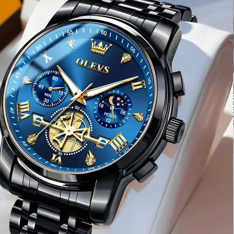 Luxury watch with blue face and black metal strap on a white cushion, brand 'OLEVS' visible.