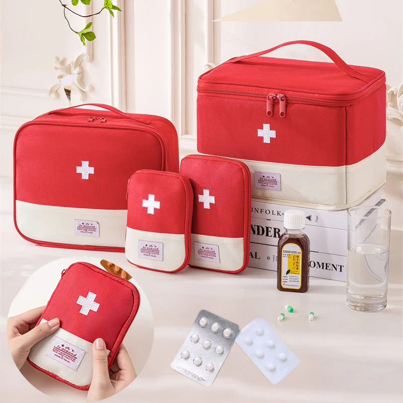 Set of red first aid kits with white crosses on a table with medical supplies.