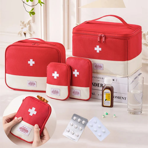 Set of red first aid kits with white crosses on a table with medical supplies.