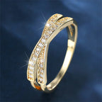 Gold ring with diamond accents on a dark blue background