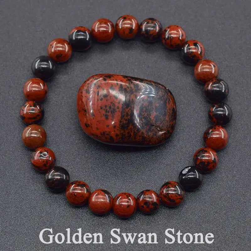 Bracelet with red and black beads and a large stone on a gray background, featuring 'Golden Swan Stone' text.