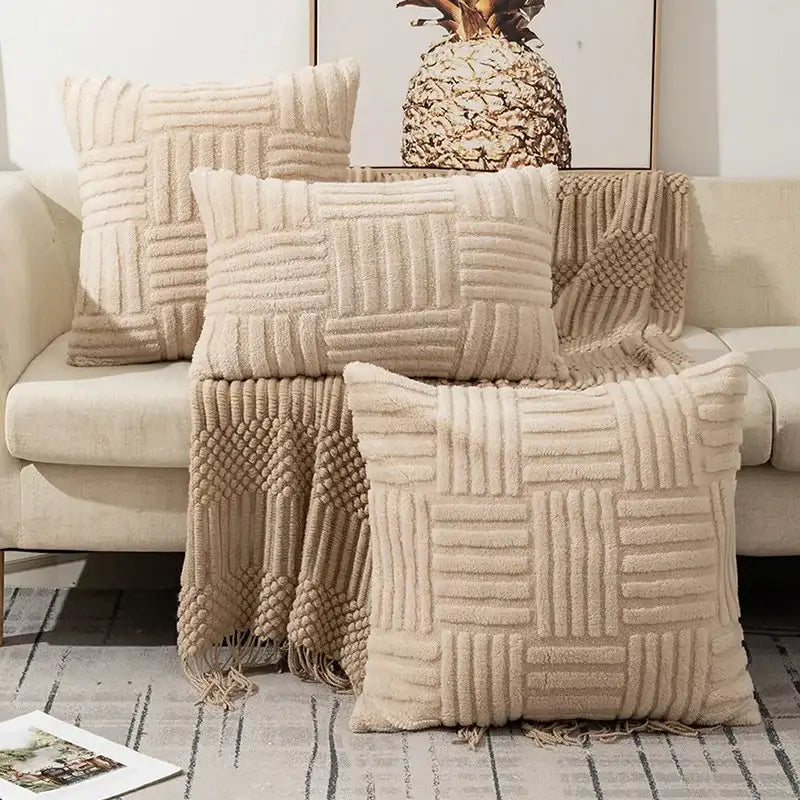 Beige textured throw blanket and pillows on a sofa with a pineapple decor item.