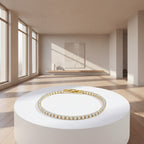 Gold bracelet with clear stones on a light gray background