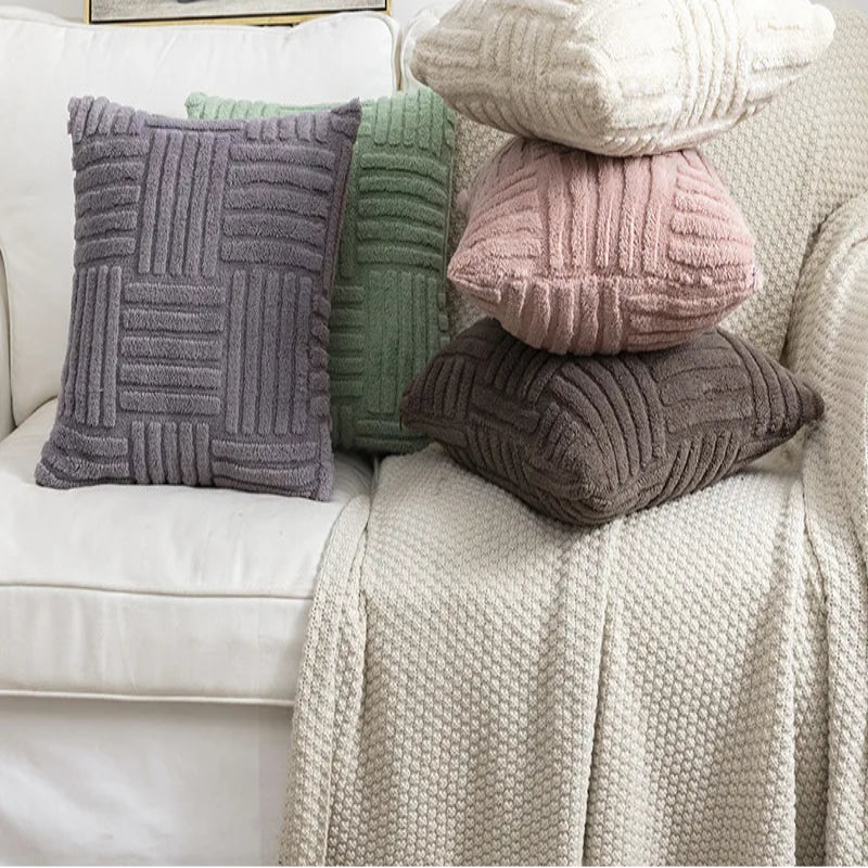 Stack of textured pillows on a sofa with a framed picture of a van in the background.