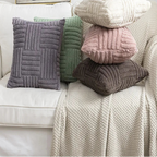 Stack of textured pillows on a sofa with a framed picture of a van in the background.