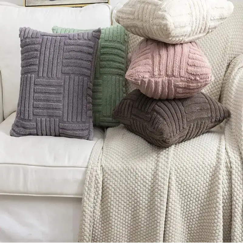 Stack of textured pillows on a sofa with a framed picture of a van in the background.
