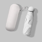 A white compact umbrella and its matching oval hard case, photographed on a light gray background with soft shadows.
