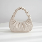 White handbag with black handle on a white surface