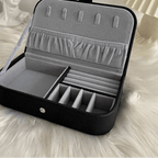 Black jewelry case with gray interior on a white fur surface