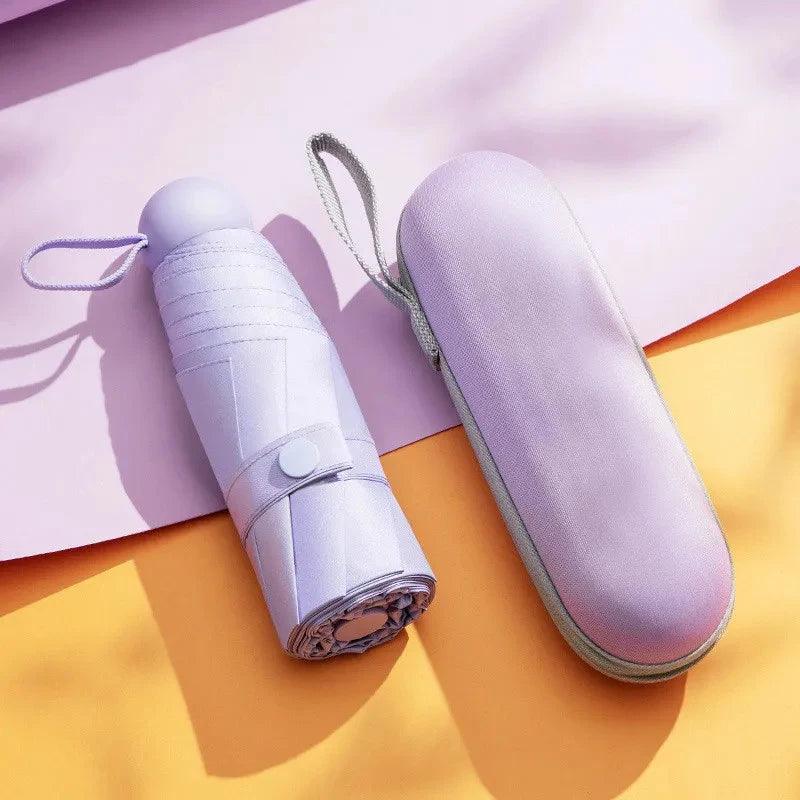 Foldable purple umbrella with matching carrying case on a colorful background