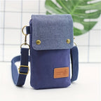 Blue crossbody bag with a textured top section and brown leather patch on a white background.