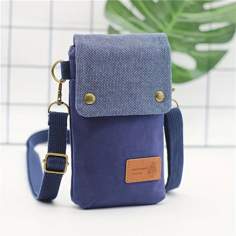 Blue crossbody bag with a textured top section and brown leather patch on a white background.