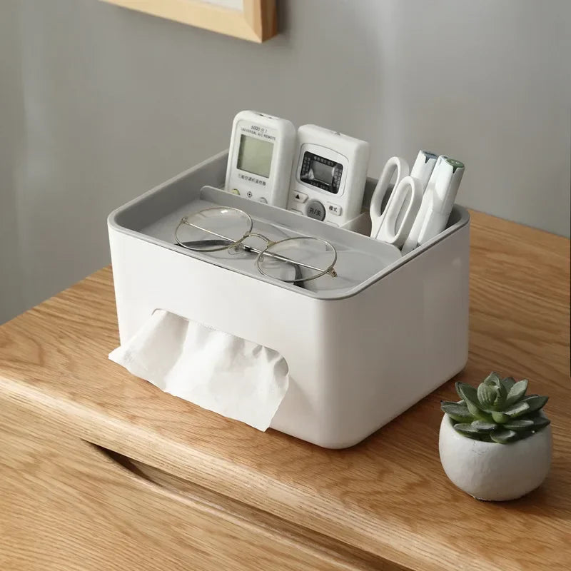 White desk organizer with electronic devices, glasses, and a plant on a wooden surface.