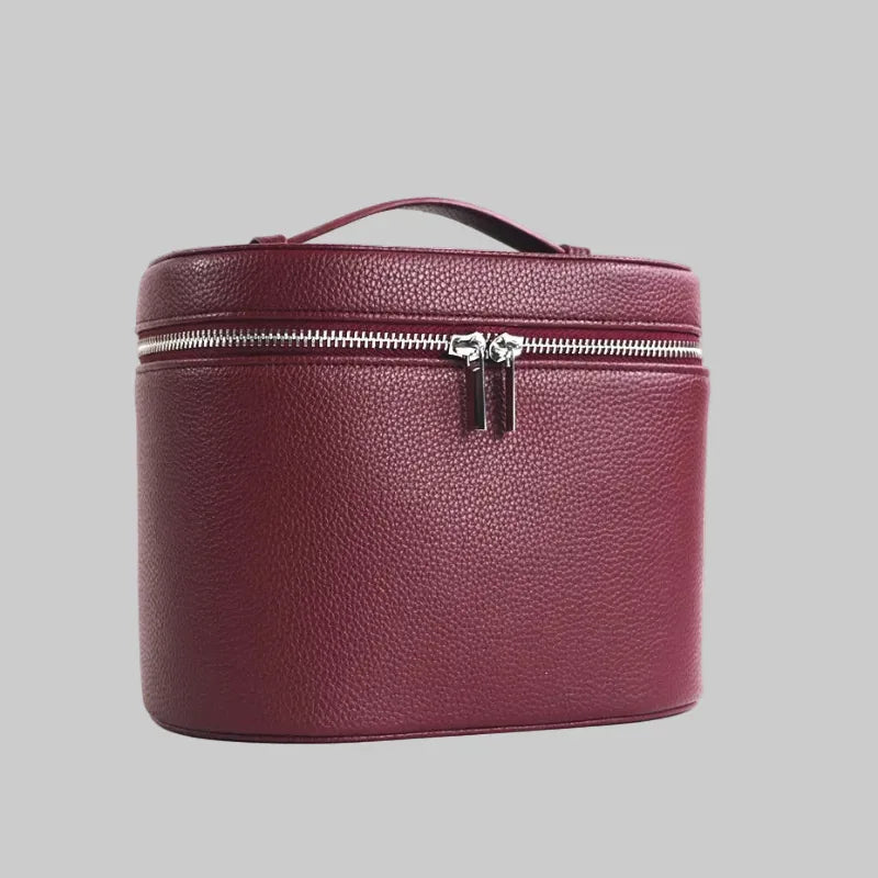 Burgundy leather travel case with a zipper on a white background