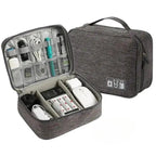 Gray travel organizer with electronic devices inside on a white background