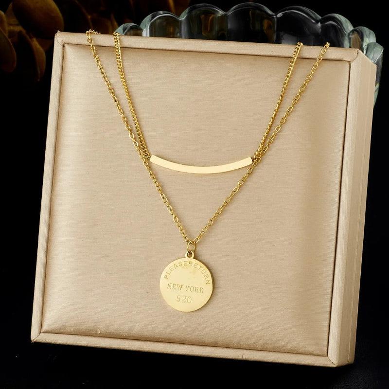 Gold necklace with a pendant on a beige display box