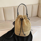 Beige woven drawstring bag with black drawstrings on a beige couch.