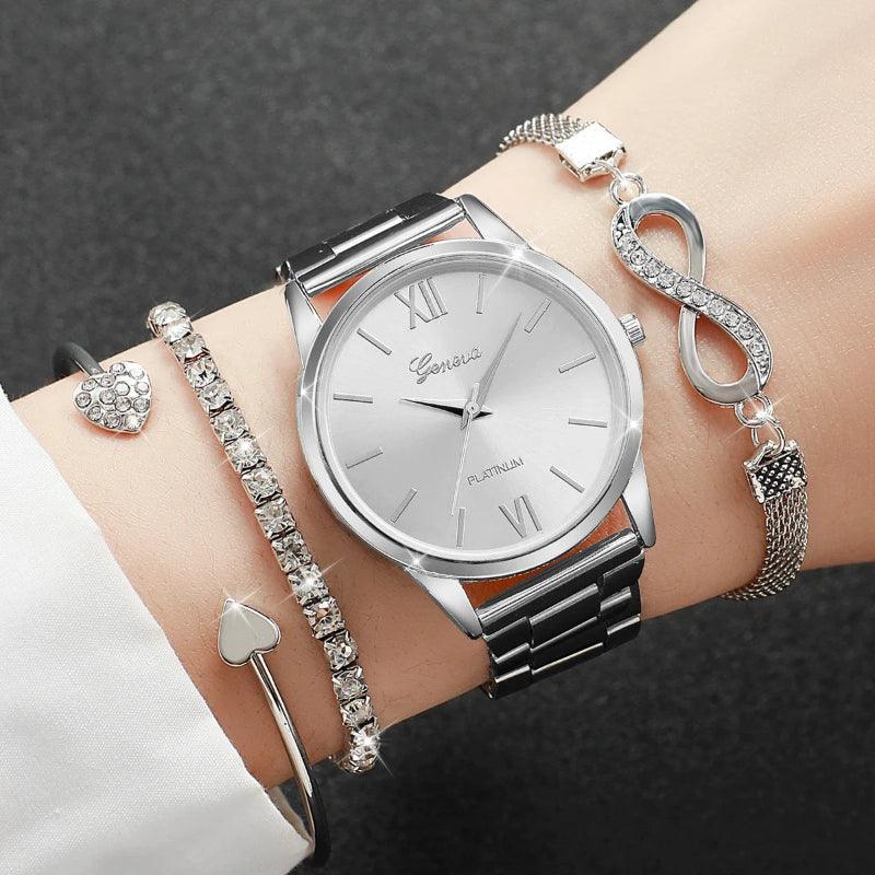 Silver watch with multiple bracelets on a wrist against a dark background