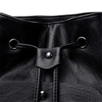 Close-up of a black leather drawstring bag with metal loops and buttons.
