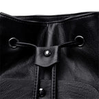 Close-up of a black leather drawstring bag with metal loops and buttons.