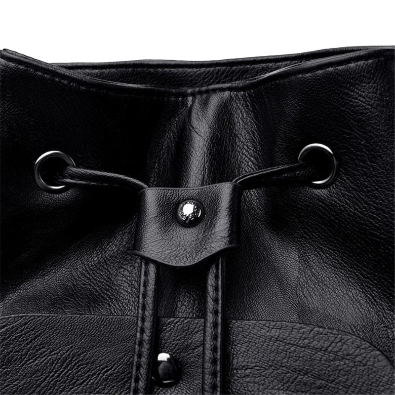 Close-up of a black leather drawstring bag with metal loops and buttons.