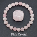 Pink crystal bracelet and stone on a dark background