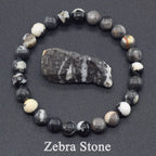 Zebra stone bracelet with a larger stone in the center on a dark background