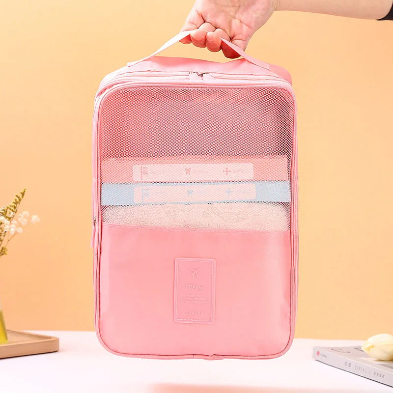 Pink travel organizer bag held by a hand against a beige background