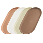 Four oval trays in overlapping rows, shown in warm neutral colors: terracotta, white, pale yellow-green, and taupe-brown, on a plain white background.