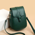 Green leather crossbody bag on a beige background
