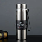 Stainless steel bottle with a label on a dark surface and gray background