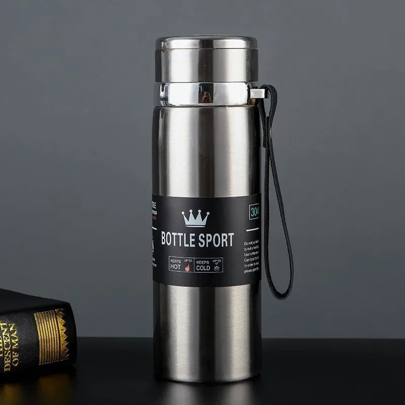 Stainless steel bottle with a label on a dark surface and gray background