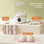 White electronic device with a clear dome on top, surrounded by laundry items on a light green background.