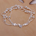 Silver beaded bracelet on a beige background