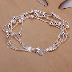 Silver beaded bracelet on a beige background