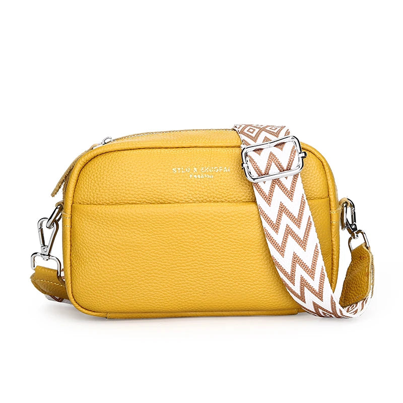 Yellow crossbody bag with a patterned strap on a white background