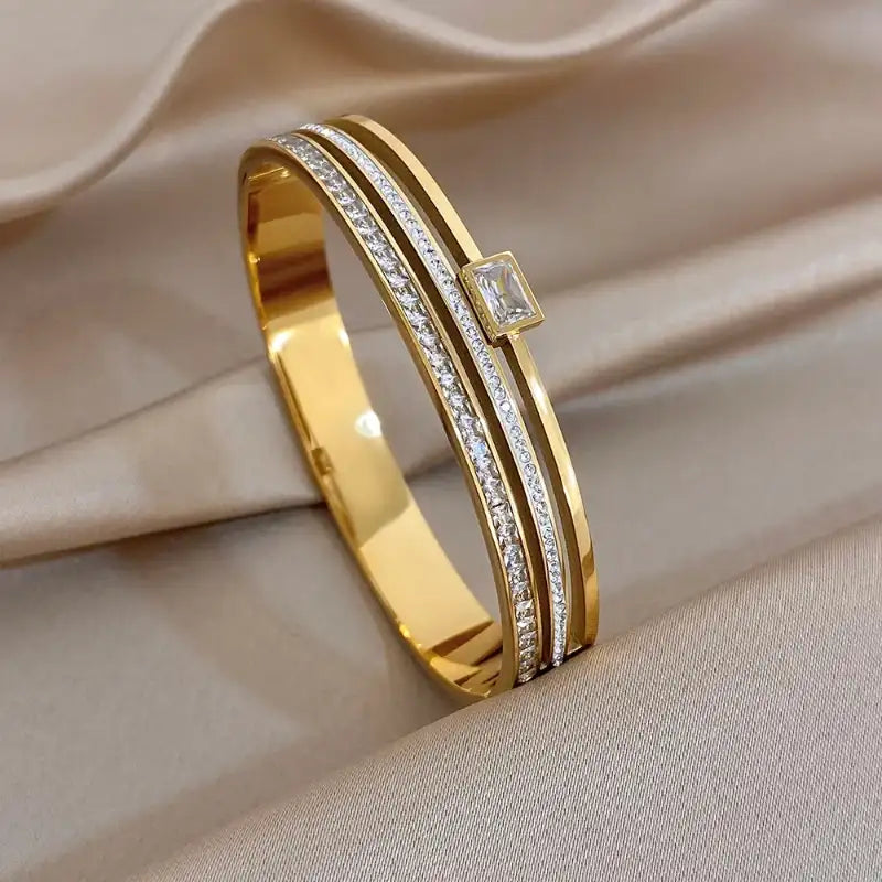 Gold bracelet with diamond on a beige fabric background