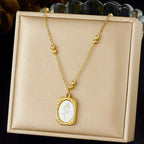 Gold necklace with a pendant on a beige display box