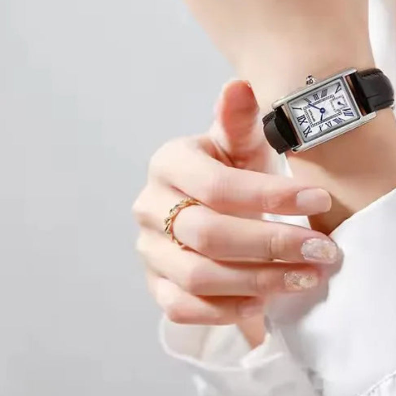 Person wearing a black and silver watch with a plain background, featuring the brand 'SANDA'.