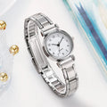 Silver watch with a white face on a light background