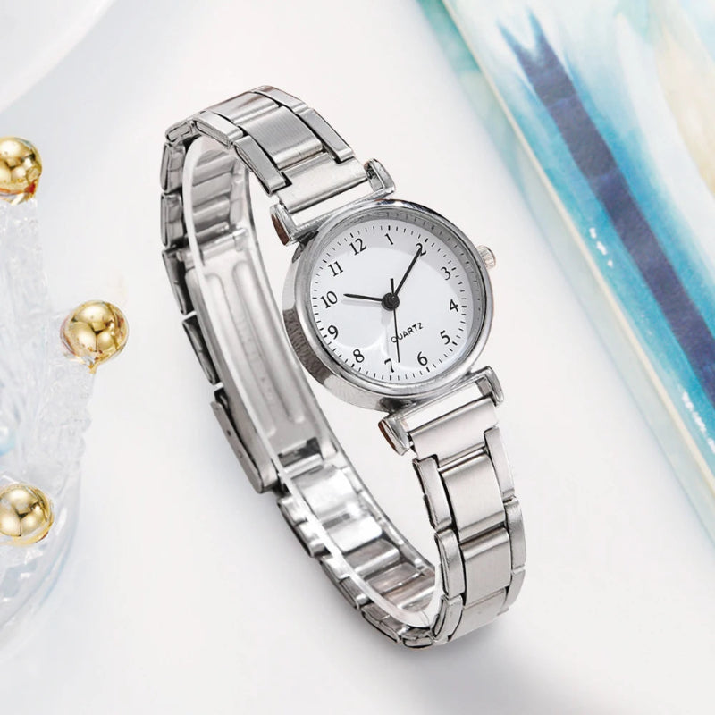 Silver watch with a white face on a light background